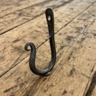 Iron hook stood up on a wooden floor