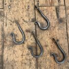 Set of 4 iron hooks on a wooden floor