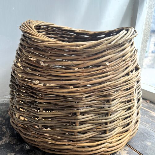 Oval shaped woven willow basket on a wood windowsill made by Jackie Carnell